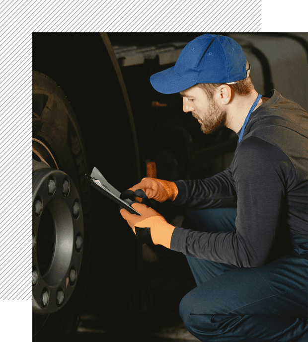 A man in blue hat and black shirt working on a truck.